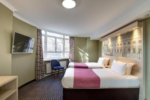 a hotel room with two beds and a window at President Hotel in London