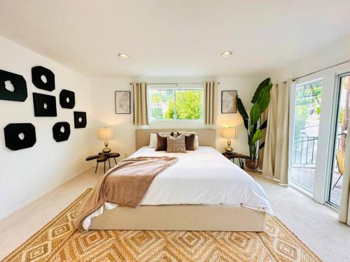 a bedroom with a large bed and a large window at Urban Oasis: Stylish Mid-Century Home in Weho in Los Angeles