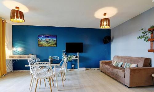 a living room with a couch and a table at T3 Le Frangipanier - Terrasse Jardin & Jacuzzi in Saint-Denis