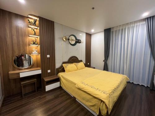 a bedroom with a yellow bed and a mirror at Hoang Huy Grand Tower - Apartment - Homestay in Hai Phong
