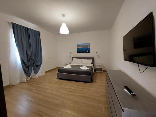 a bedroom with a bed and a flat screen tv at Residence Del Tellaro in Noto Marina