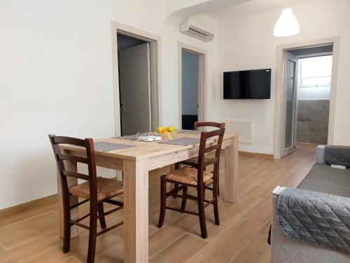 a dining room with a wooden table and chairs at Residence Del Tellaro in Noto Marina
