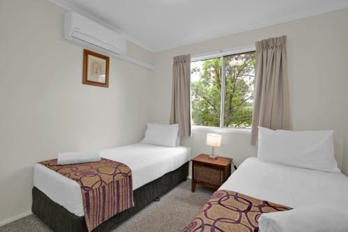 a hotel room with two beds and a window at Starline Alpacas Farmstay Resort in Broke