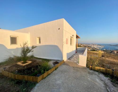 a house on a hill with a staircase next to it at Lux Mykonos house in Agios Stefanos