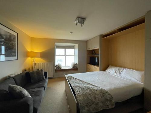um quarto com uma cama e um sofá em Chalet 3 em Mount Hotham