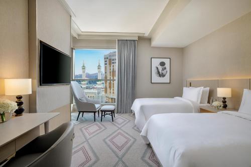 メッカにあるJumeirah Jabal Omar Makkahのベッド2台とテレビが備わるホテルルームです。