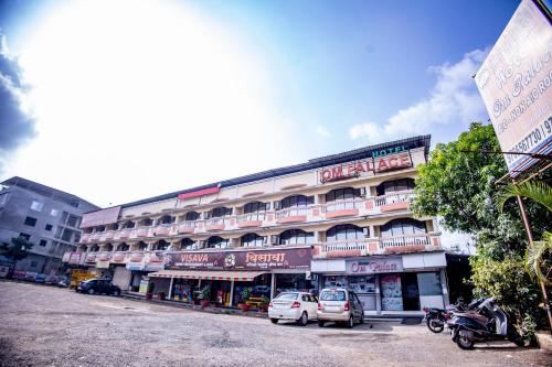 a building with cars parked in front of it at Hotel Om Palace in Lonavala