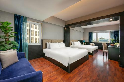 a hotel room with a bed and a couch at Ja Cosmo Hotel and Spa in Hanoi