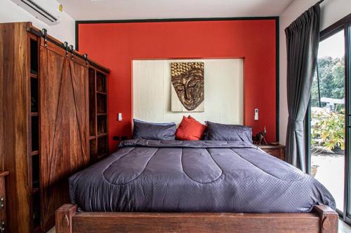a bedroom with a large bed with a red wall at RUSARDI Poolvilla Ao Nang - new Villa 4 Bedrooms 4 Bathrooms, 10m Pool in Ao Nang Beach