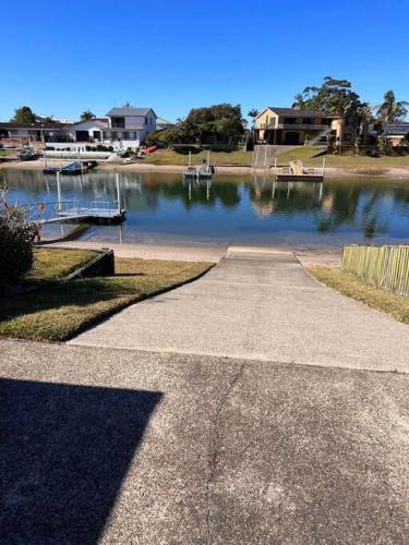 a walkway leading to a body of water with houses at Waterfront Bliss in Port Macquarie