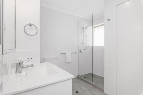 un bagno bianco con lavandino e doccia di 7 Pelican Beach Resort a Noosaville