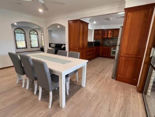 a dining room with a white table and chairs at Waterfront Bliss in Port Macquarie