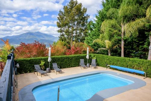 una piscina en un patio con sillas en Myee Alpine Retreat en Mount Beauty