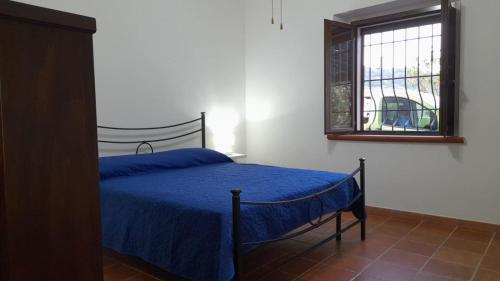 Un dormitorio con una cama azul y una ventana en Villa Mattia en Montegiordano