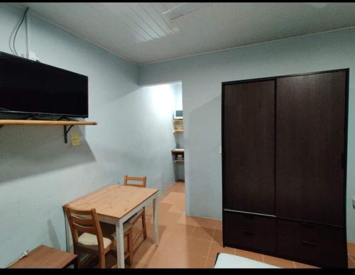 Habitación con mesa, TV y armario de madera. en Airport Premier Hotel, en Les Lagunes