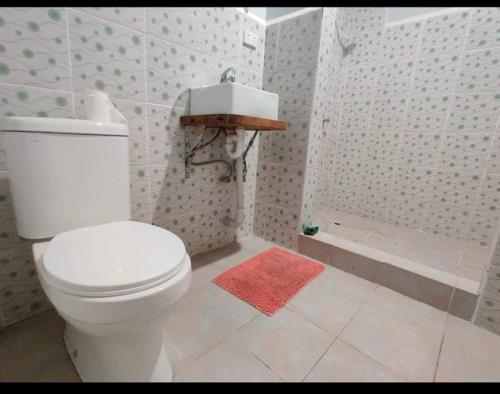 a bathroom with a white toilet and a shower at PORT VILA Airport Hotel in Les Lagunes