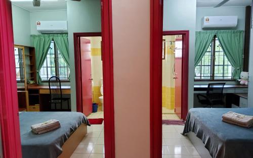 a room with two beds and a desk and a room with a mirror at Putrajaya Transit Romestay in Putrajaya