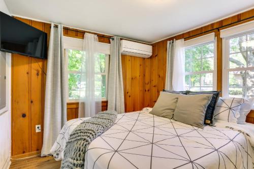 1 dormitorio con 1 cama y 2 ventanas en All-Season Vernon Township Lake House Retreat!, en Vernon Township