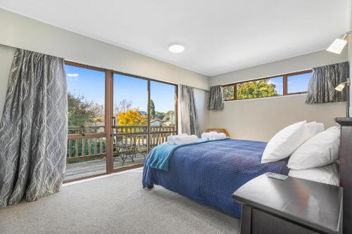 a bedroom with a bed and a large window at M&M's Hotspot in Rotorua