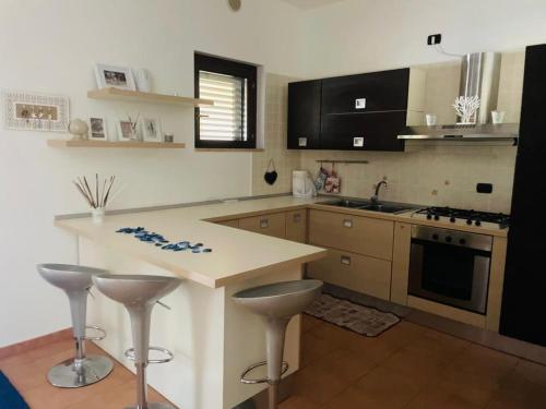a kitchen with a counter and two stools in it at Il mare di Matera in Policoro