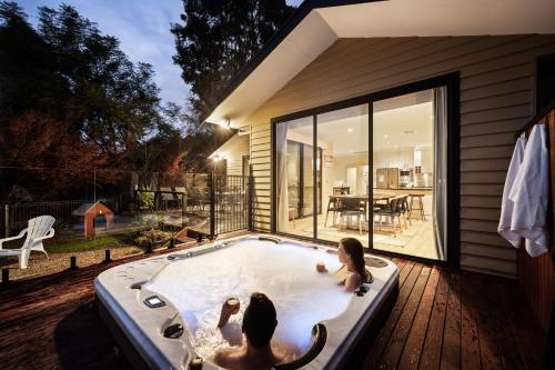 two children playing in a jacuzzi in a backyard at Myee Alpine Retreat in Mount Beauty
