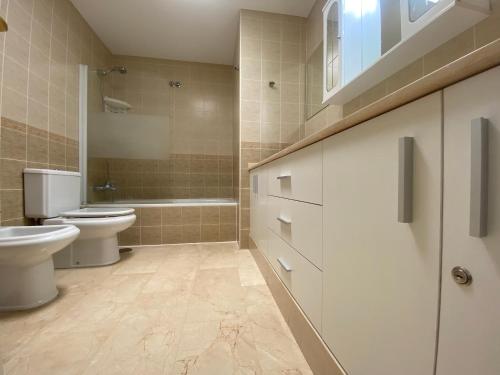 a bathroom with a toilet and a sink and a tub at Apartment With Jacuzzi and pool access in Puerto Rico de Gran Canaria