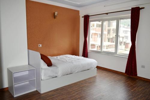 a bedroom with a bed and a window at Mount Star Homestay in Kathmandu