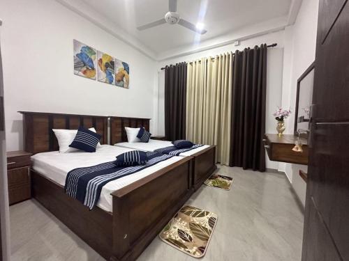 DreamScape Holiday Apartment Kalutara في كالوتارا: غرفة نوم بسرير كبير مع وسائد زرقاء