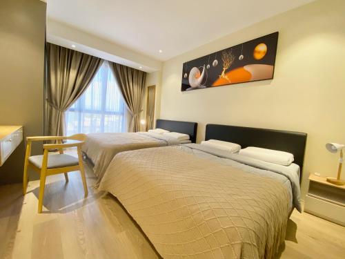 a bedroom with two beds and a table and a window at Armadale Residence 3R3B GalaCity Airport in Kuching