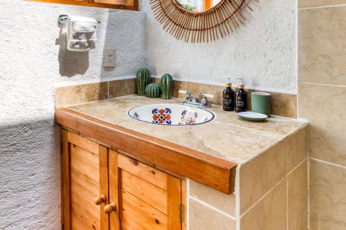 a bathroom counter with a sink and a mirror at Beautiful & Warm Cabin with Lakeview 3BR 2 5BA in Valle de Bravo