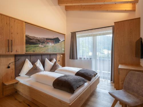 ein Schlafzimmer mit einem großen Bett und einem großen Fenster in der Unterkunft Bauernhof Mühlbichl in Söll