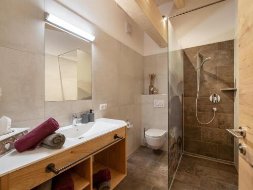 La salle de bains est pourvue d'un lavabo et d'une douche. dans l'établissement Bauernhof Mühlbichl, à Söll
