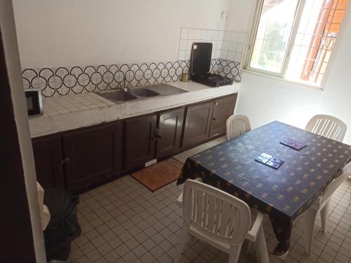 - une cuisine avec une table, des chaises et un évier dans l'établissement LocaTriolet, à Saint-Denis