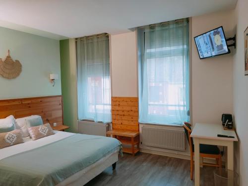 1 dormitorio con 1 cama, escritorio y 2 ventanas en Le Royal Hôtel, en Saint-Pol-sur-Ternoise