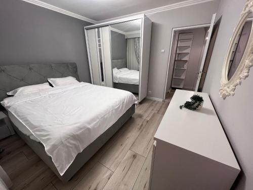 een slaapkamer met een bed, een tafel en een spiegel bij EBI Apartment in Cluj-Napoca