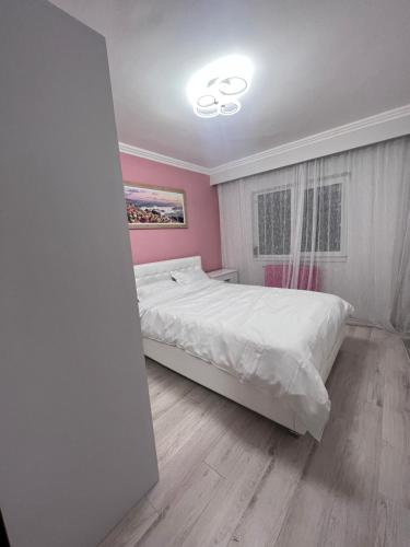 een slaapkamer met een wit bed en roze muren bij EBI Apartment in Cluj-Napoca
