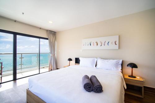 a bedroom with a bed with a view of the ocean at Patong tower superior seaview 4BR210(2102) in Patong Beach