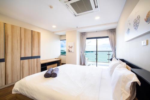 a bedroom with a bed with a view of the ocean at Patong tower superior seaview 4BR210(2102) in Patong Beach