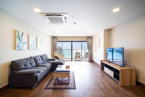 a living room with a couch and a flat screen tv at Patong tower superior seaview 4BR210(2102) in Patong Beach