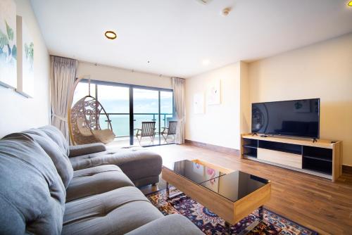 a living room with a couch and a tv at Patong tower superior seaview 4BR210(2102) in Patong Beach