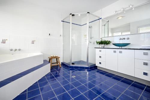 a bathroom with a shower and a blue tile floor at Stunning Mooloolaba Waterfront Home -10 guests ZB1 in Mooloolaba