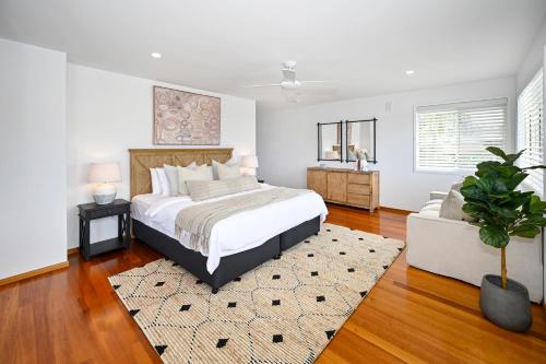 um quarto com uma cama e um vaso de plantas em Stunning Mooloolaba Waterfront Home -10 guests ZB1 em Mooloolaba