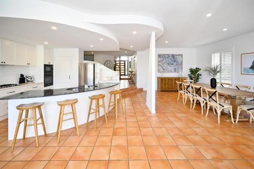 an open kitchen and dining room with a table and chairs at Stunning Mooloolaba Waterfront Home -10 guests ZB1 in Mooloolaba