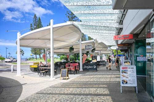 a group of white umbrellas on a city street at Stunning Mooloolaba Waterfront Home -10 guests ZB1 in Mooloolaba