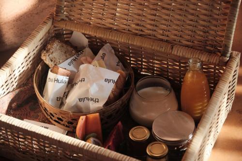 a basket with food and drinks and a glass of juice at Further Hotel in Canggu