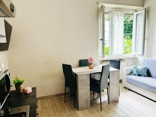 a living room with a table and chairs and a couch at Appartamento Gufetto in Ivrea