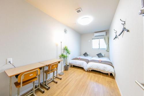 sypialnia z biurkiem i łóżkiem w pokoju w obiekcie GUEST House彩 w Osace