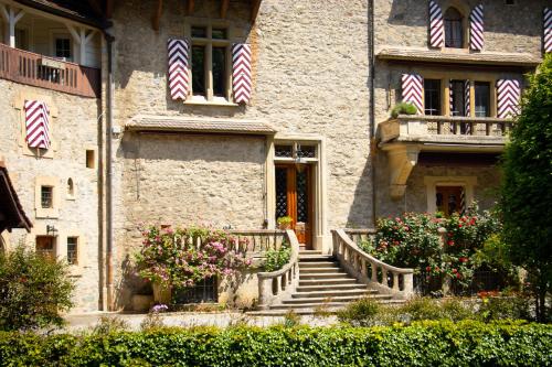 a building with stairs and flowers in front of it at Cabana & Nuit de Château au bord du Lac Léman in Lugrin