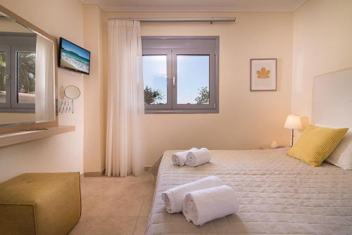 1 dormitorio con 1 cama grande y toallas. en Allea Hotel and Apartments, en Toroni