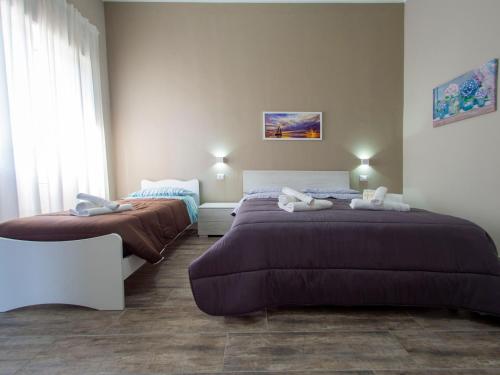 a bedroom with two beds and a window at Villa Paestum in Paestum